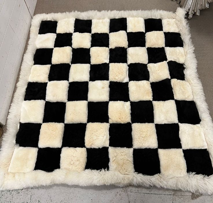 A checker style faux fur rug (170cm x 160cm)