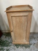 A pine bedside cupboard opening to shelves (H77cm W41cm D38cm)