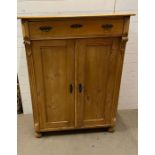 A pine tall cabinet with drawers and cupboard (H133cm W100cm D47cm)