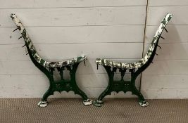 A pair of metal bench ends, painted green in a Gothic style.