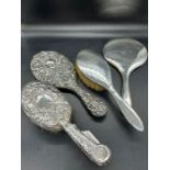 A selection of four silver backed dressing table brushes and mirrors, two of each. (1.155g)