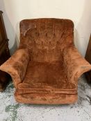 An Easy mid century armchair with winged arms and button back