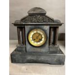 A French black slate striking mantle clock on raised mount and Corinthian columns