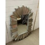 A silver wall mirror with plank style frame in a starburst style.