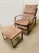 A suede armchair and foot stool, padded arm rests on powder coated base frame (H90cm W88cm)