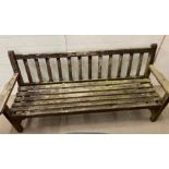 A wooden weathered teak slat bench (H85cm W180cm D62cm)
