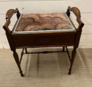 A mahogany piano stool opens up for sheet music