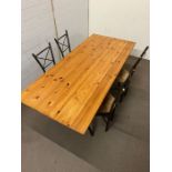 A pine dining table on metal legs and four chairs (180cm x 78cm x 72cm)