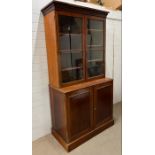 A William IV style library bookcase with moulded cornice above adjustable shelves and glazed