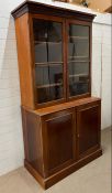 A William IV style library bookcase with moulded cornice above adjustable shelves and glazed
