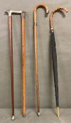 Three vintage walking sticks and one umbrella