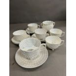 A pearlized tea set comprising of five cups and saucers, a moustache cup and sugar bowl