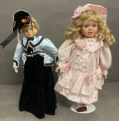 A pair of vintage dolls on stands