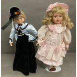 A pair of vintage dolls on stands