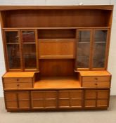 A Mid Century teak wall unit with glazed doors and cupboards under. Two parts by Parker Knoll (