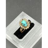 A Middle Eastern gold ring with central turquoise stone (Approximate size K)