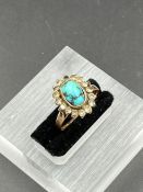 A Middle Eastern gold ring with central turquoise stone (Approximate size K)