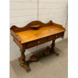 A pine wash stand with drawers to centre and jug stand to base (H89cm W110cm D48cm)