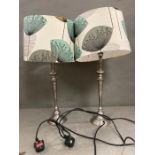 A pair of lamps with dandelion print lamp shades