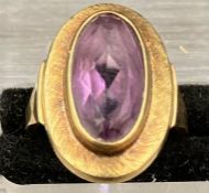 A gold ring, marked 585 total approximate weight 4.3g with central purple stone. Size L