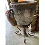 A carved garden pot with ringed handles to sides on a wrought iron stand (Stand H47cm Pot H44cm