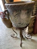 A carved garden pot with ringed handles to sides on a wrought iron stand (Stand H47cm Pot H44cm