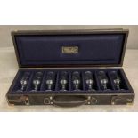 A black leather travelling shooting case with brass fitments of eight drinking glasses by William
