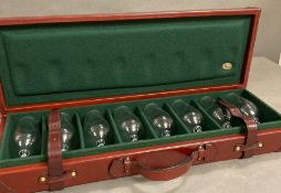 A leather travelling shooting case with eight sherry glasses by Rev Pavon