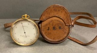 A Troughton and Simms pocket barometer in a leather case