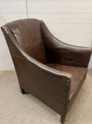 A leather low club chair with stud work to sides