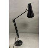An angle poise black desk lamp