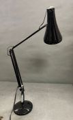 An angle poise black desk lamp