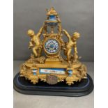 An Eight day Ormolu and enamel eight day clock featuring cherubs and under a glass dome.
