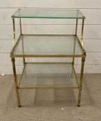 A three tier brass and glass side table