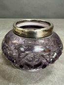 A cut glass pot with a silver rim