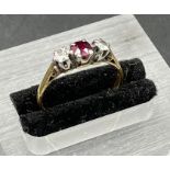A 9ct gold ring with ruby with ruby and diamond side stones Size L 1/2