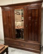 A triple mahogany wardrobe with mirror and two drawers under (H208cm W188cm D58cm)