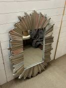 A silver wall mirror with plank style frame in a starburst style.