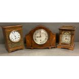A selection of three mantle clocks, one walnut and two light oak