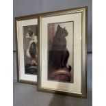 Two contemporary prints of cats, sitting on the arm of a sofa 39cm x 64cm