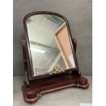 A mahogany dressing table mirror on scrolling arms