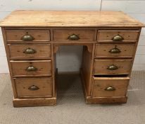 A pine knee hole desk, flanked with drawers and brass shell handles (H77cm W108cm D50cm)