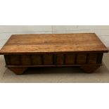 A hardwood low coffee table with metal work detail to sides (H38cm W131cm D58cm)