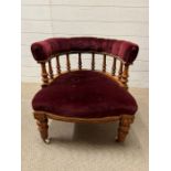 A Victorian tub chair with claret velvet upholstery and spindle back