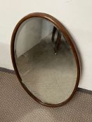 An oval wall mirror