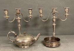 A pair of silver plated candlesticks, wine coaster and a teapot.