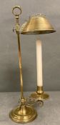 A brass candle stick with brass shade