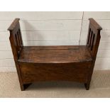 An oak settle or hall bench with hinged seat opening to a recess