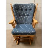 A pine rocking chair with cushions