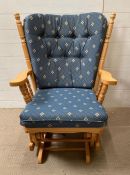 A pine rocking chair with cushions
